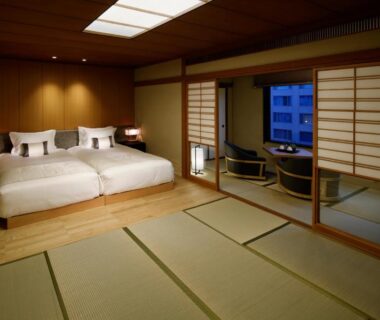 Tatami room with twin beds, shoji screens and seating area at Takanawa Hanakohro in Tokyo, Japan