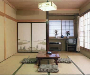 Traditional tatami room with low table, zabuton cushions, shoji screens and painted fusuma doors at Takanoya, Niigata