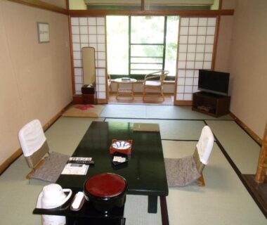 Traditional tatami room with low table, floor chairs, shoji screens and greenery view at Takaragawa Onsen Ousenkaku, Gunma