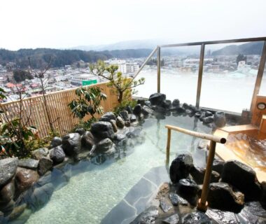 Outdoor stone onsen bath overlooking Takayama town at Takayama Ouan in Gifu