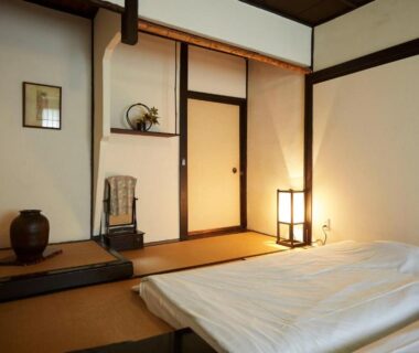 Traditional tatami room with futon, tokonoma alcove, sliding doors and warm lantern light at Takeyaso Ryokan Hyōgo
