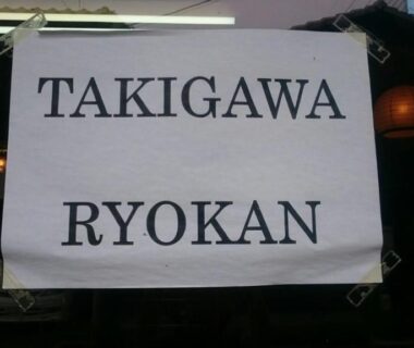 White noren sign reading Takigawa Ryokan hung over a Kyoto entrance