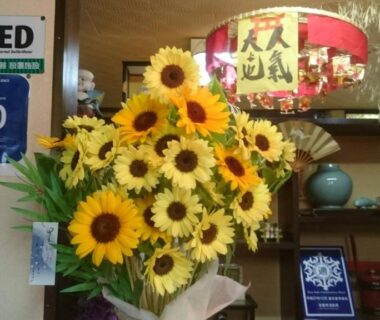 Bouquet of sunflowers in Takigawa Ryokan lobby with decorative lantern and reception area, Kyoto
