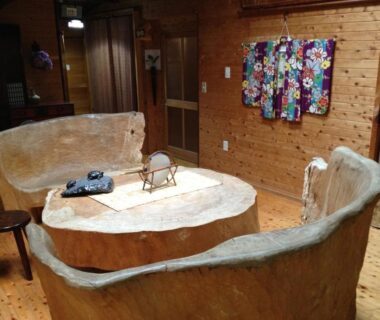 Rustic carved stone seating with low table inside Takimi Onsen Inn interior, Nagano Chūbu