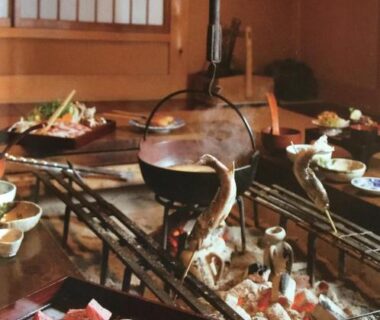 Low table with irori hearth grilling skewers and assorted dishes in a traditional tatami dining room