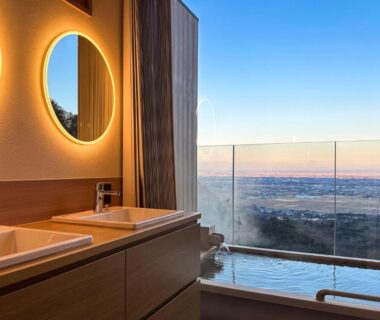 Indoor soaking tub and dual sinks with glass valley view at Takimotokan Yuki No Sato in Gifu