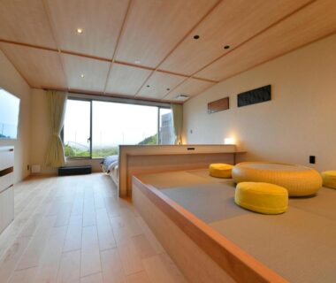 Spacious modern tatami room with low round cushions, wooden flooring and large window view at Takimotokan Yuki No Sato, Gifu