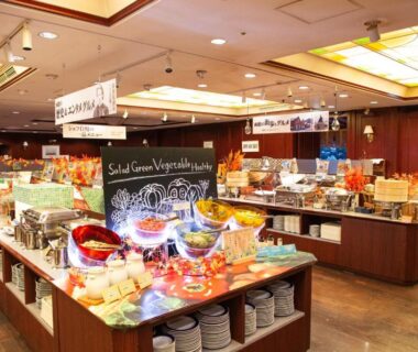 Salad bar and buffet counters in Takuboku Tei dining hall with plates and warm lighting