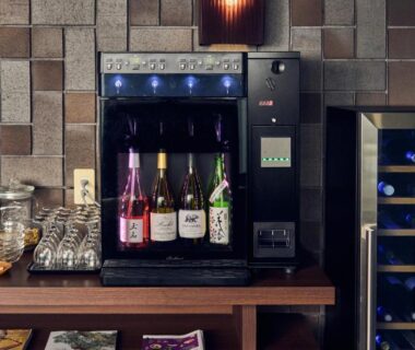 Counter with sake bottles in dispenser, glassware and wine cooler at Tamana Onsen Happouen Kumamoto Kyushu