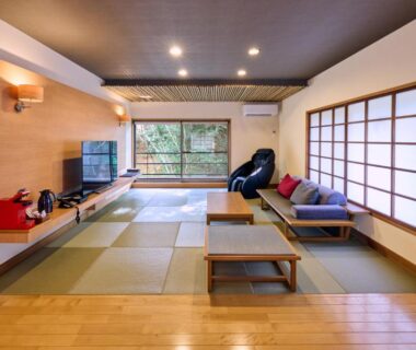 Tatami room with low table, shoji screens, sofa and massage chair at Tamana Onsen Happouen, Kumamoto
