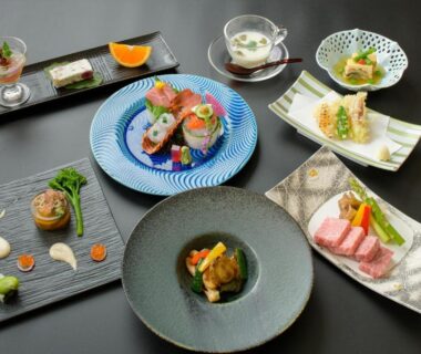 Variety of small plated Japanese courses on black table at Tamaya Ryokan, Nagano
