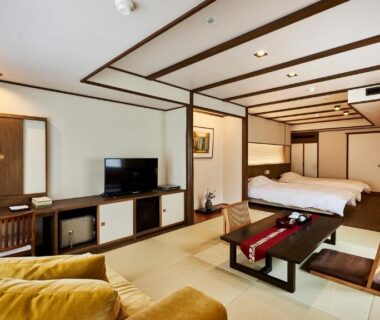 Spacious tatami room with low table, seating area, twin beds and shoji-style screens at Tamaya Ryokan Nagano