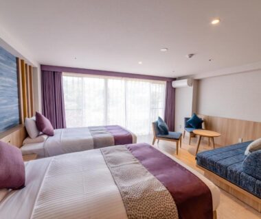 Modern twin room with two beds, sofa seating, wooden floor and large window at Tateshina Grand Hotel Takinoyu Nagano