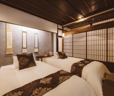Twin beds on tatami floor with shoji screens in a Tateshina Shinyu Onsen room, Nagano