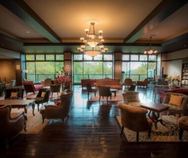 Spacious lounge with sofas, piano, wooden floors and large windows at Tateshina Shinyu Onsen in Nagano