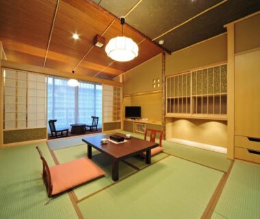 Traditional tatami room with low table, zabuton cushions, shoji screens and window seating at Tatsumikan in Gunma