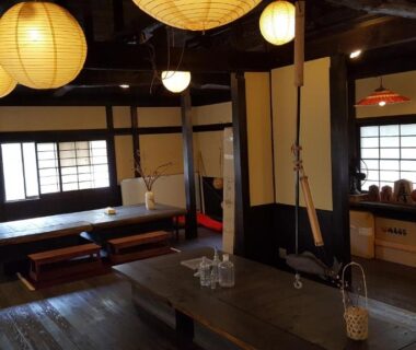Traditional wooden lounge with low tables, paper lanterns and shoji windows at Tawaraya Ryokan in Ōita, Kyūshū