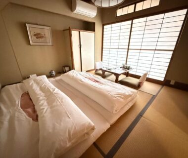 Traditional tatami room with futon bedding, shoji screens and low table at Tazuru in Kyoto
