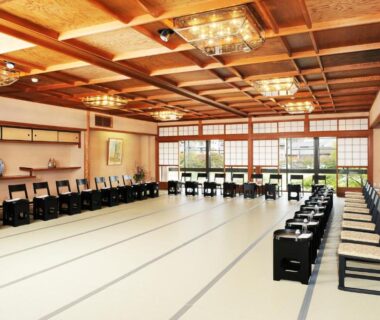 Long tatami hall with zaisu chairs and shoji screens at Tazuru ryokan in Kyoto, Kansai