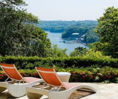 Two orange loungers on terrace overlooking a wooded bay at Teisho Basaratei Mie