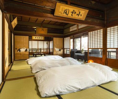 Traditional tatami room with futon bedding, shoji screens and wooden beams at Temple Hotel 正暦寺 in Kyoto