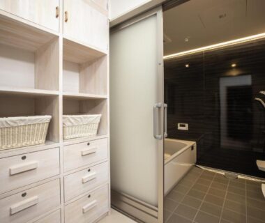 Frosted sliding door bath with wooden shelving and wicker baskets at Temple Hotel 正暦寺 in Kyoto