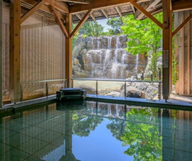 Indoor bathing area facing stone waterfall at Tendo Hotel Yamagata