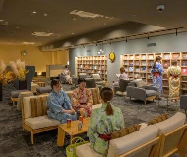 Guests in yukata seated in book-lined lounge at Tendo Hotel Yamagata
