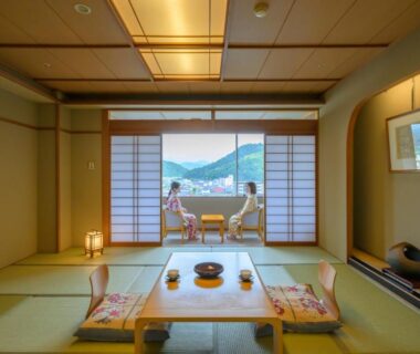 Tatami room at Tendo Hotel with low table, shoji screens and balcony seating overlooking lake and mountains in Yamagata