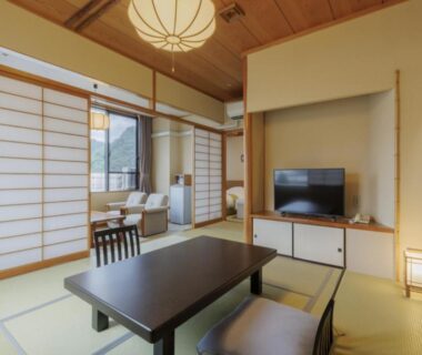 Tatami room with low table, shoji screens and seating at Tendo Onsen TAKINOYU in Yamagata