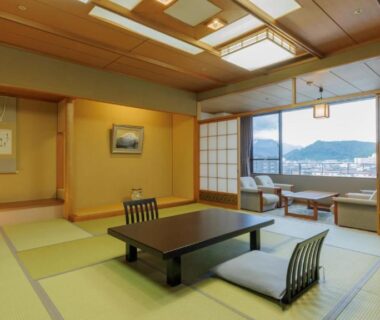 Tatami room with low table and seating by large window at Tendo Onsen TAKINOYU, Yamagata, Tōhoku, Japan