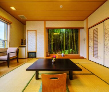 Tatami room with low wooden table, shoji screens and bamboo garden view at Tenku Yubo Seikaiso in Oita Japan