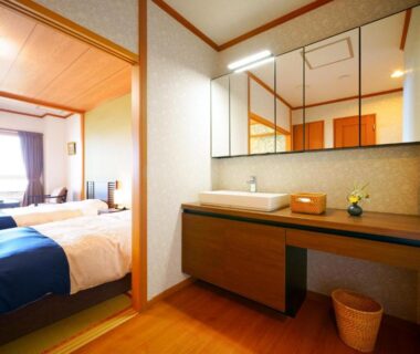 Tatami bedroom with twin beds, washstand and mirror at Tenku Yubo Seikaiso in Ōita
