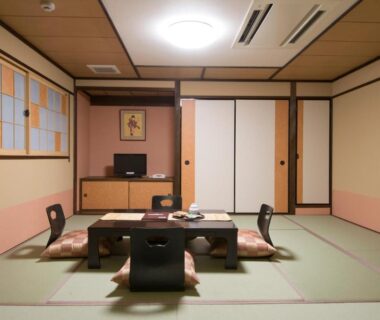 Japanese tatami room with low table, floor chairs, shoji screens and built-in cabinet at Tenpyo Ryokan Nara