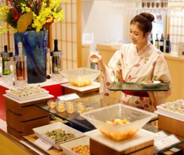 Staff in yukata arranging buffet dishes at Tenseien ryokan dining area, Kanagawa, Kantō