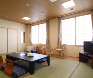 Japanese tatami room with low table, floor cushions, sliding screens and window seating at Teshio Onsen Yubae