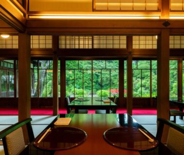 Traditional dining room with wooden beams, shoji screens and lush garden view at The Fujiya Hotel in Kanagawa