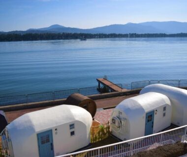 White waterfront pod cabins beside calm water at The Gran Resort Amanohashidate, Kyoto Kansai
