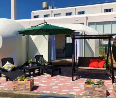 Rooftop terrace seating with umbrella, pergola, cushioned sofas and planter boxes at The Gran Resort Amanohashidate in Kyoto