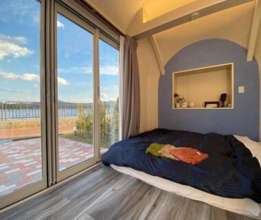 Futon bedding near sliding glass doors opening to terrace and water view at The Gran Resort Amanohashidate Kyoto