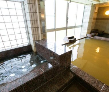 Tiled indoor onsen baths with large windows and stone steps at The Gran Resort Arima in Hyōgo