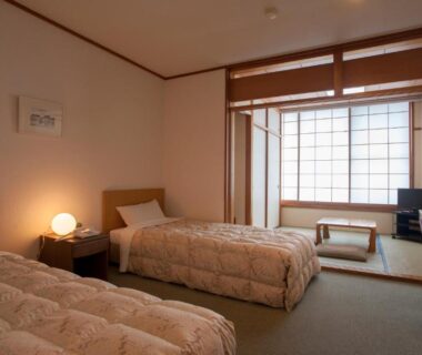 Twin beds and tatami seating with shoji screens in a room at The Gran Resort Elegante Atami, Shizuoka