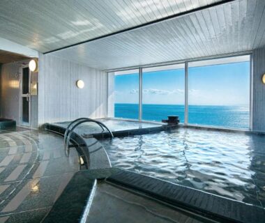 Indoor onsen bath with large windows overlooking the sea at Gran Resort Elegante Awajishima in Hyōgo, Kansai