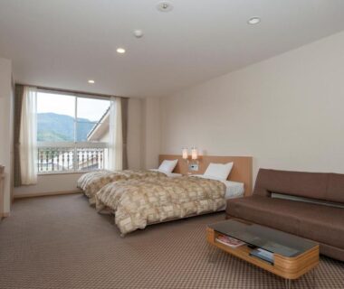 Carpeted twin room with two beds, sofa and balcony with mountain view, The Gran Resort Kinosaki Hyōgo