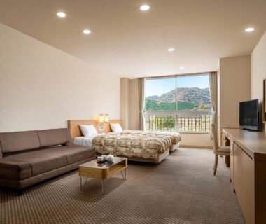 Twin beds, sofa, low table and balcony with mountain view at The Gran Resort Kinosaki Hyōgo