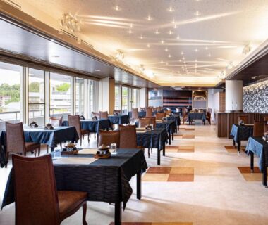 Spacious dining room with tables and large windows overlooking greenery at Gran Resort Princess Arima in Hyōgo
