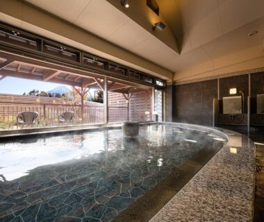 Large tiled indoor onsen with open windows at The Gran Resort Princess Fujikawaguchiko in Yamanashi
