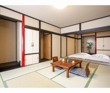 Tatami room with futon, low table and sliding doors at The RYOKAN O in Gifu, Chūbu, Japan