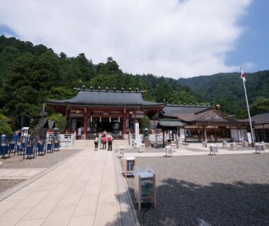 Shrine courtyard with paved path, wooden halls and forested hills near Togakubo, Kanagawa