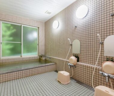 Tiled bathing area with stools and hand showers at Togakubo in Kanagawa